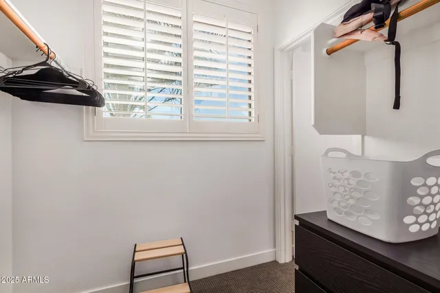 a view of a small space with racks on the wall and a window