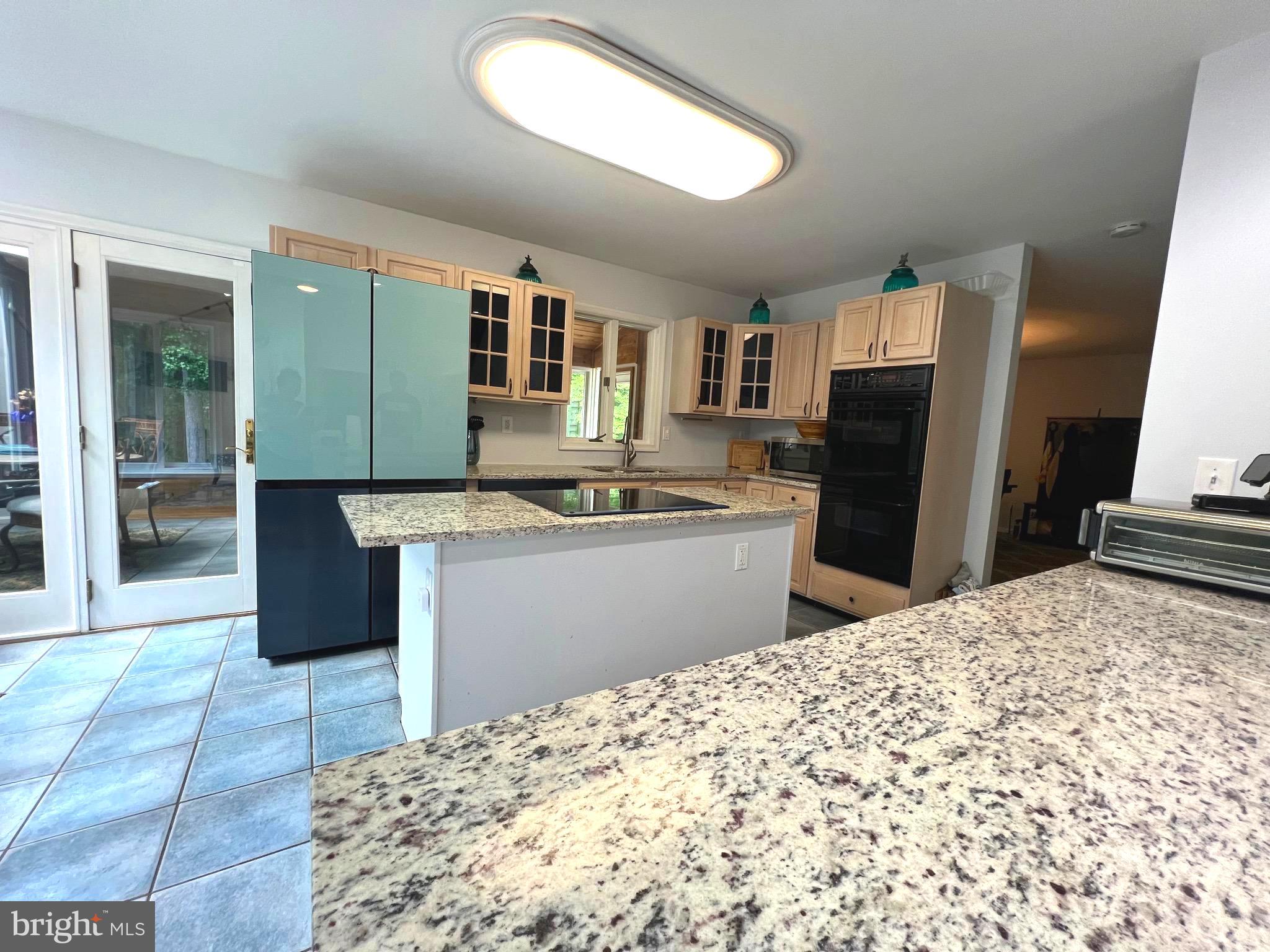 6450 Meadowlark Drive Dunkirk, MD 20754 - Photo 8 of 36 a kitchen with stainless steel appliances kitchen island granite countertop a refrigerator and a stove top oven