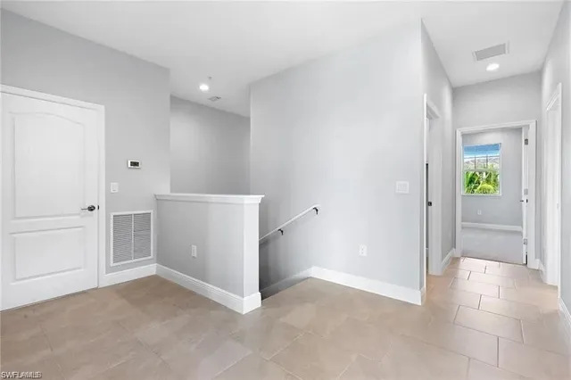 an empty room with windows and entrance to other room