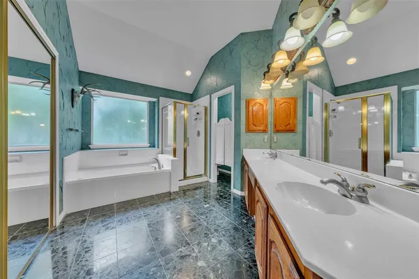 a bathroom with a tub sink shower and mirror
