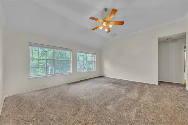 an empty room with windows and fan
