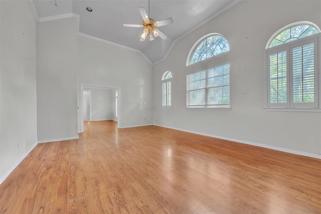 1409 Jackson Road Keller, TX 76262 - Photo 5 of 35 an empty room with wooden floor chandelier fan and windows
