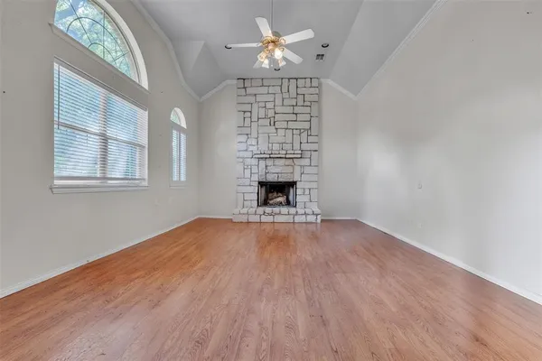 a view of an empty room with a window and fireplace