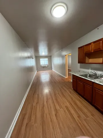 a view of a hallway with wooden floor and a living room