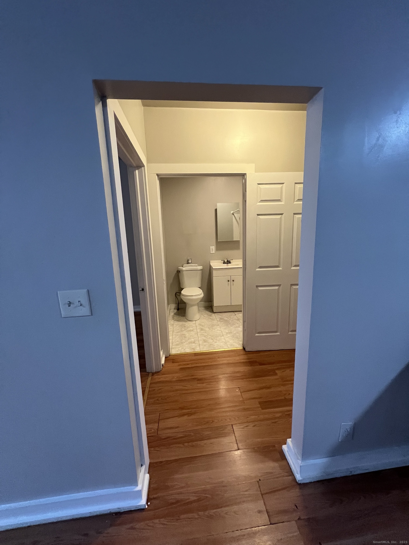 385 Putnam Avenue, Unit 26 Hamden, CT 06517 - Photo 4 of 11 a view of a hallway with wooden floor and a living room