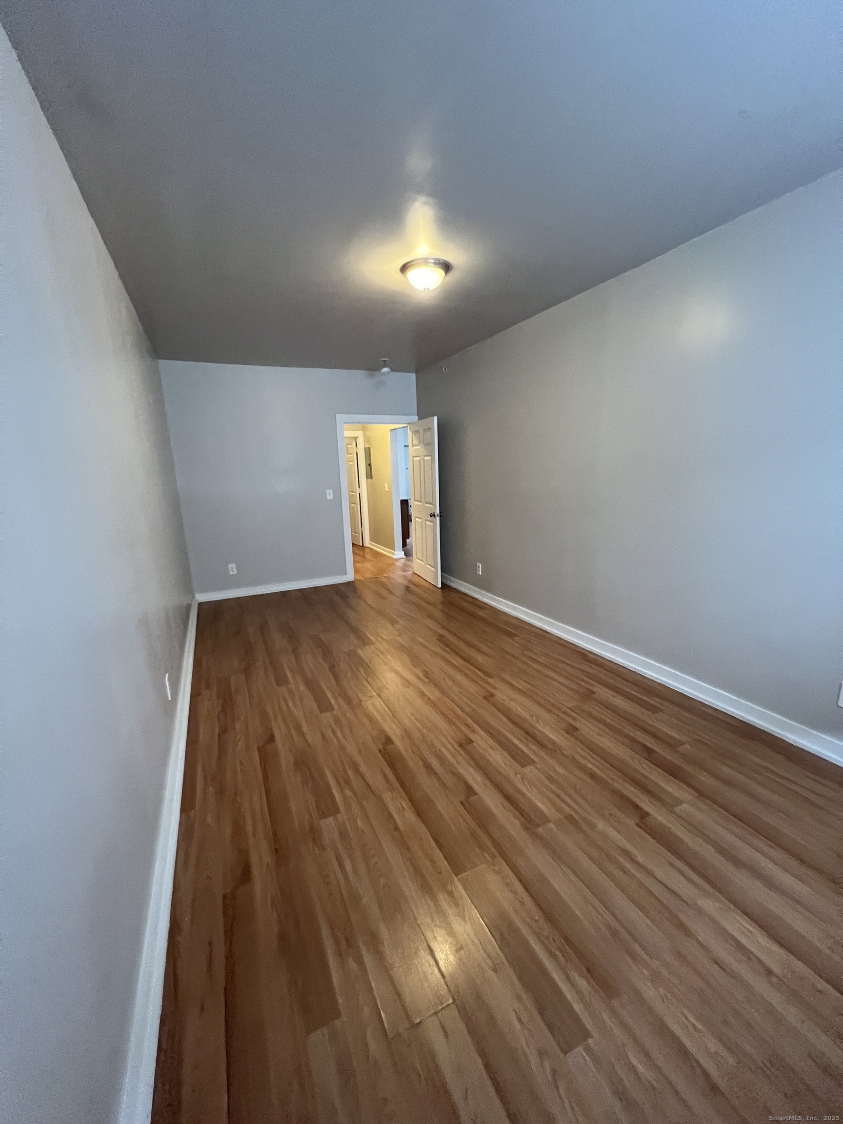 385 Putnam Avenue, Unit 26 Hamden, CT 06517 - Photo 7 of 11 a view of an empty room and wooden floor