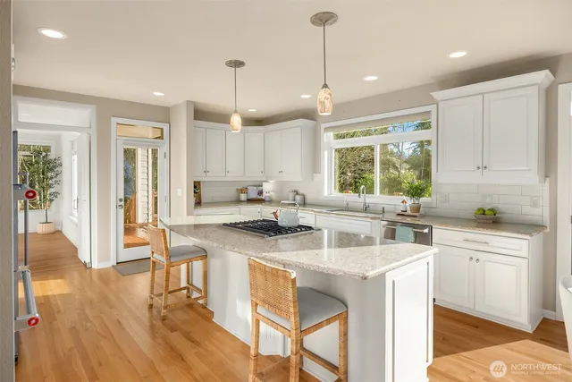 a kitchen with a stove a sink a dining table and chairs