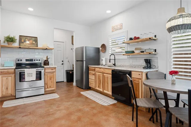 a kitchen with stainless steel appliances a stove a sink island and a refrigerator