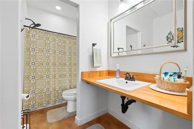 a bathroom with a sink a toilet and shower curtain
