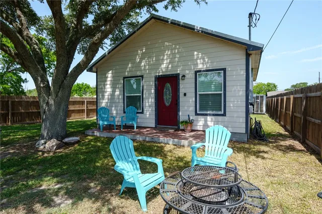 a view of a house with backyard and sitting area