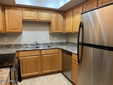 a kitchen with stainless steel appliances granite countertop a refrigerator and a stove top oven
