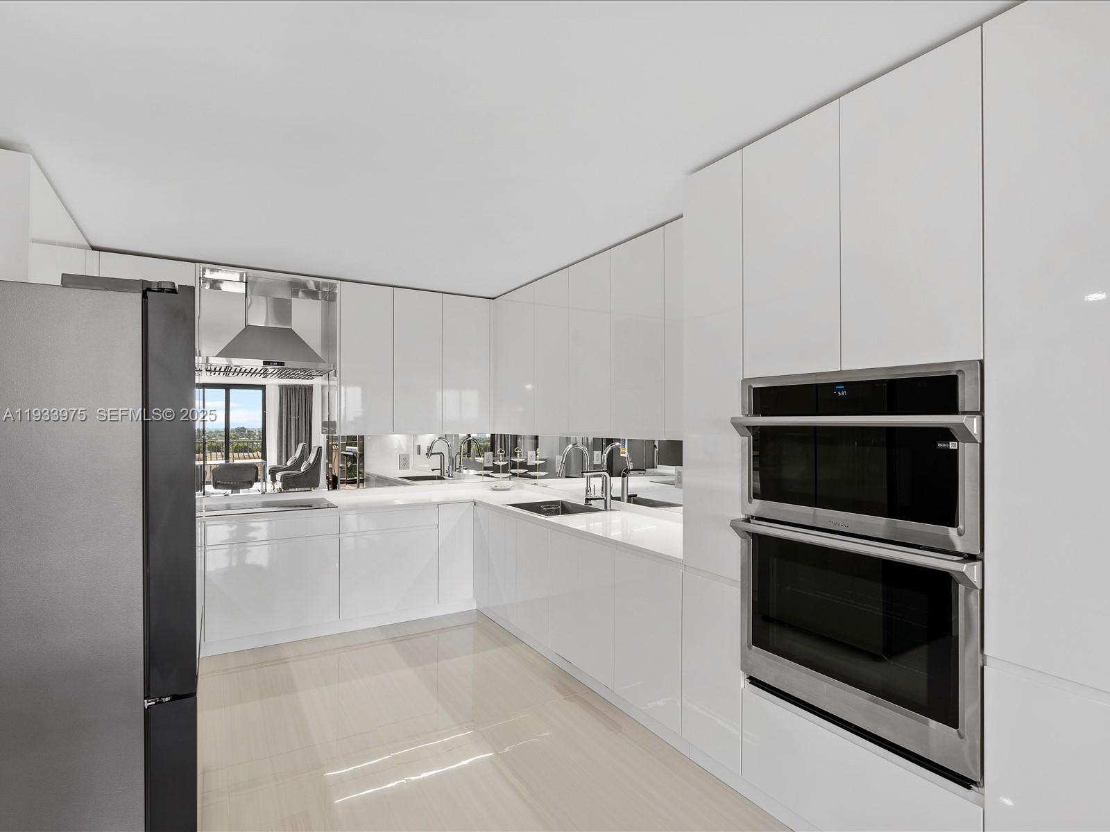 8877 Collins Avenue, Unit 704 Surfside, FL 33154 - Photo 11 of 39 a kitchen with granite countertop a stove and a microwave