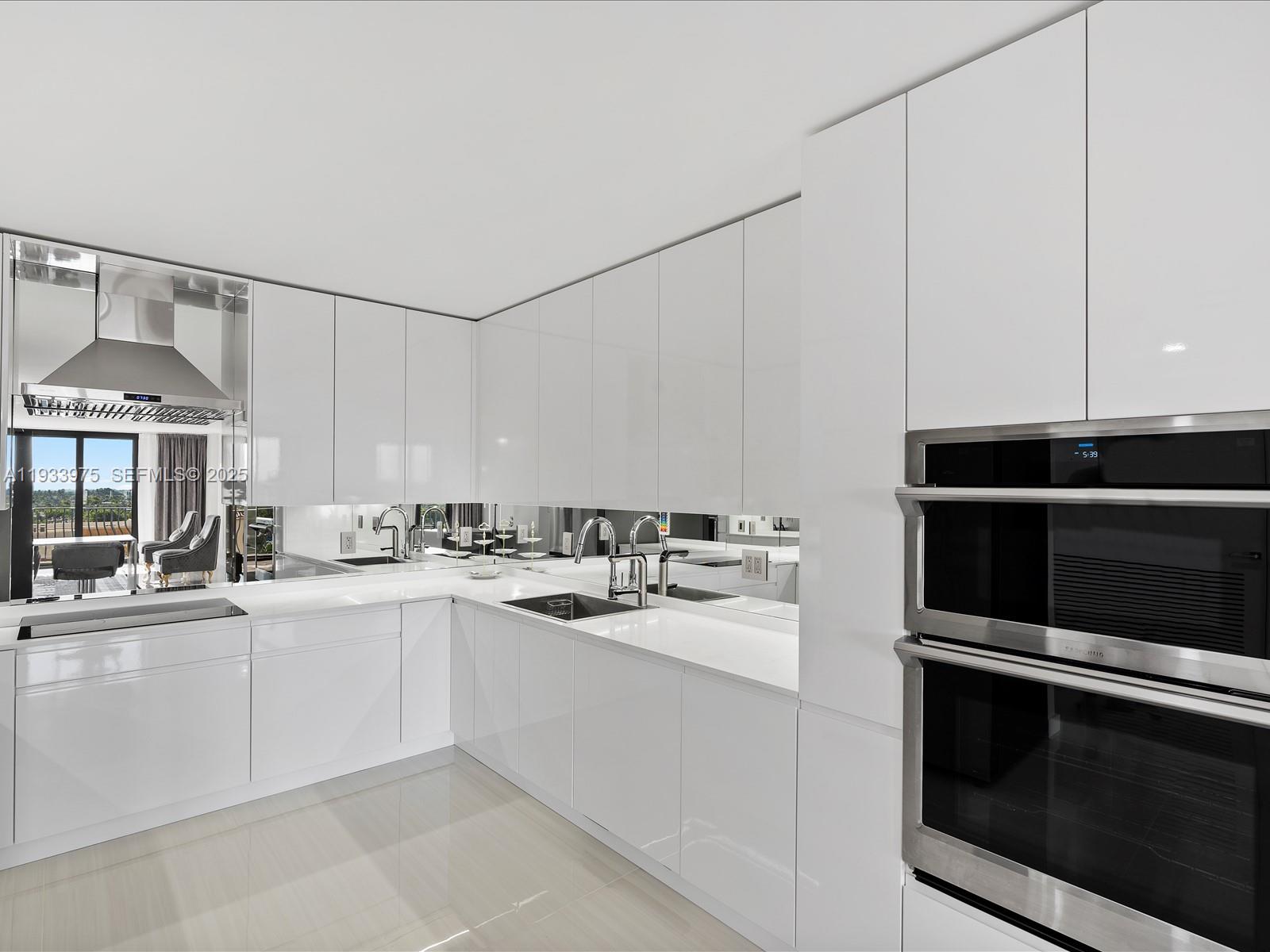 8877 Collins Avenue, Unit 704 Surfside, FL 33154 - Photo 12 of 39 a kitchen with a sink and cabinets