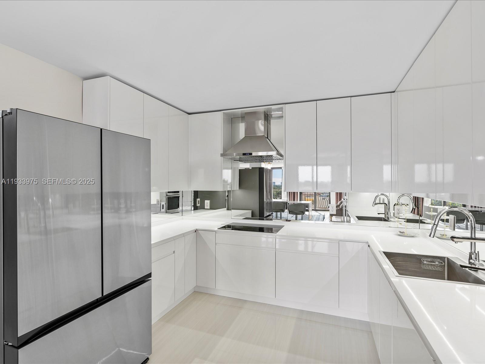 8877 Collins Avenue, Unit 704 Surfside, FL 33154 - Photo 14 of 39 a kitchen with stainless steel appliances a refrigerator sink and cabinets