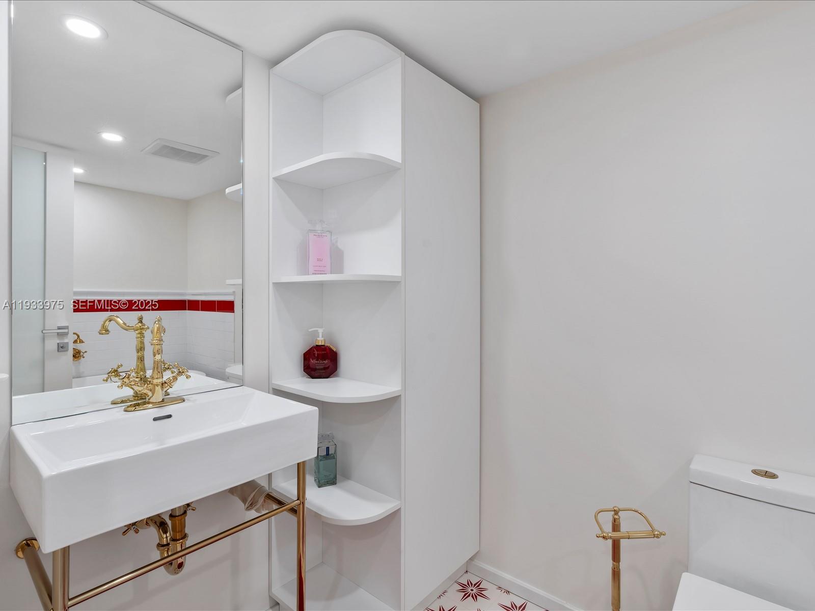 8877 Collins Avenue, Unit 704 Surfside, FL 33154 - Photo 15 of 39 a bathroom with a sink mirror vanity and toilet