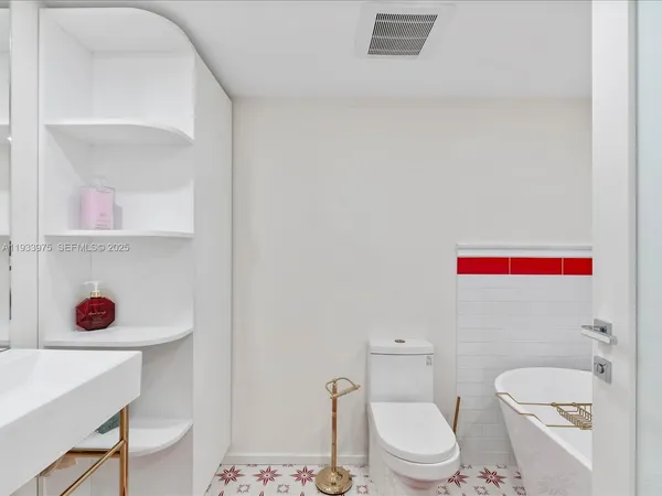 a white toilet sitting next to a bathroom sink