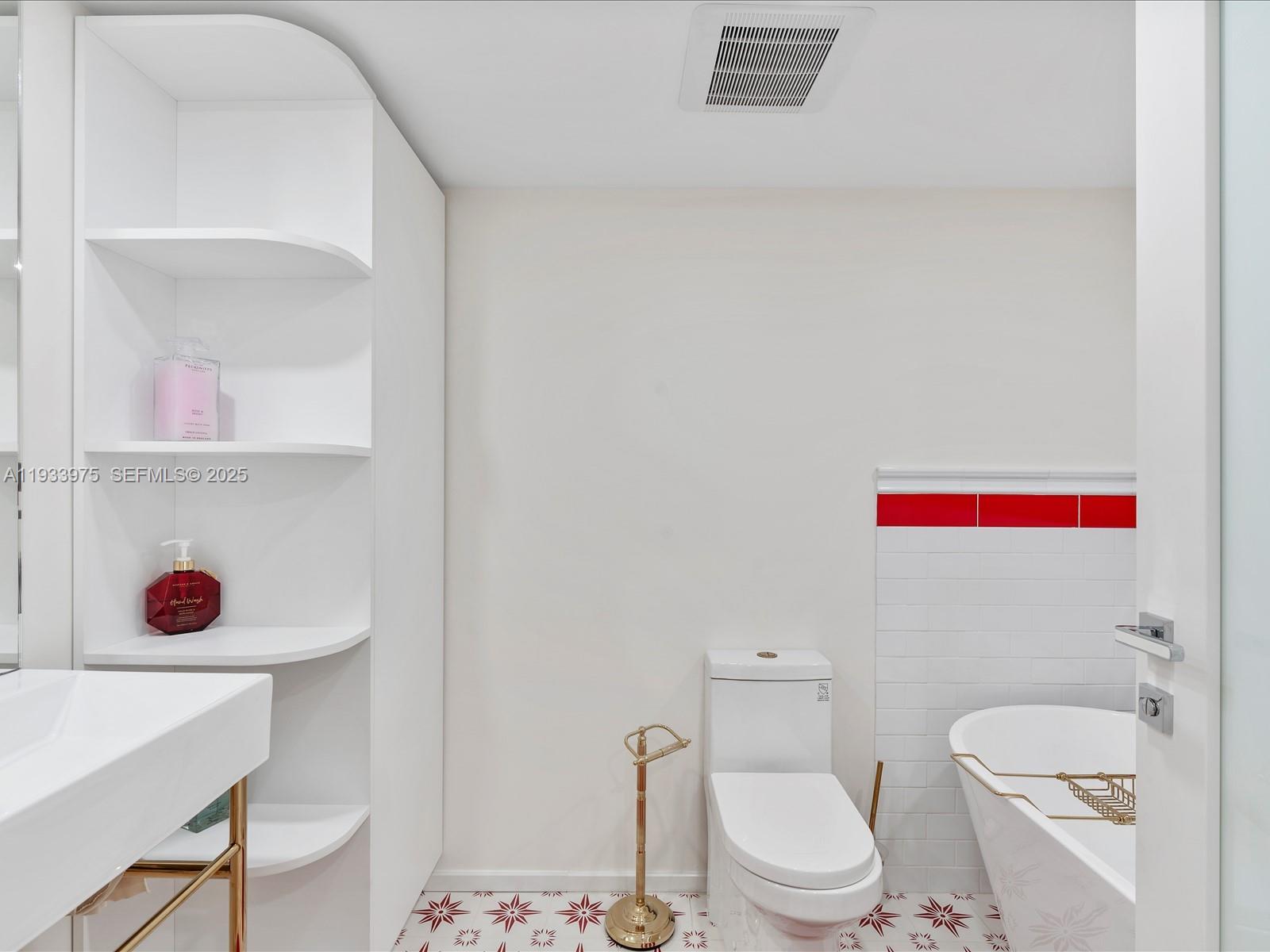 8877 Collins Avenue, Unit 704 Surfside, FL 33154 - Photo 17 of 39 a white toilet sitting next to a bathroom sink