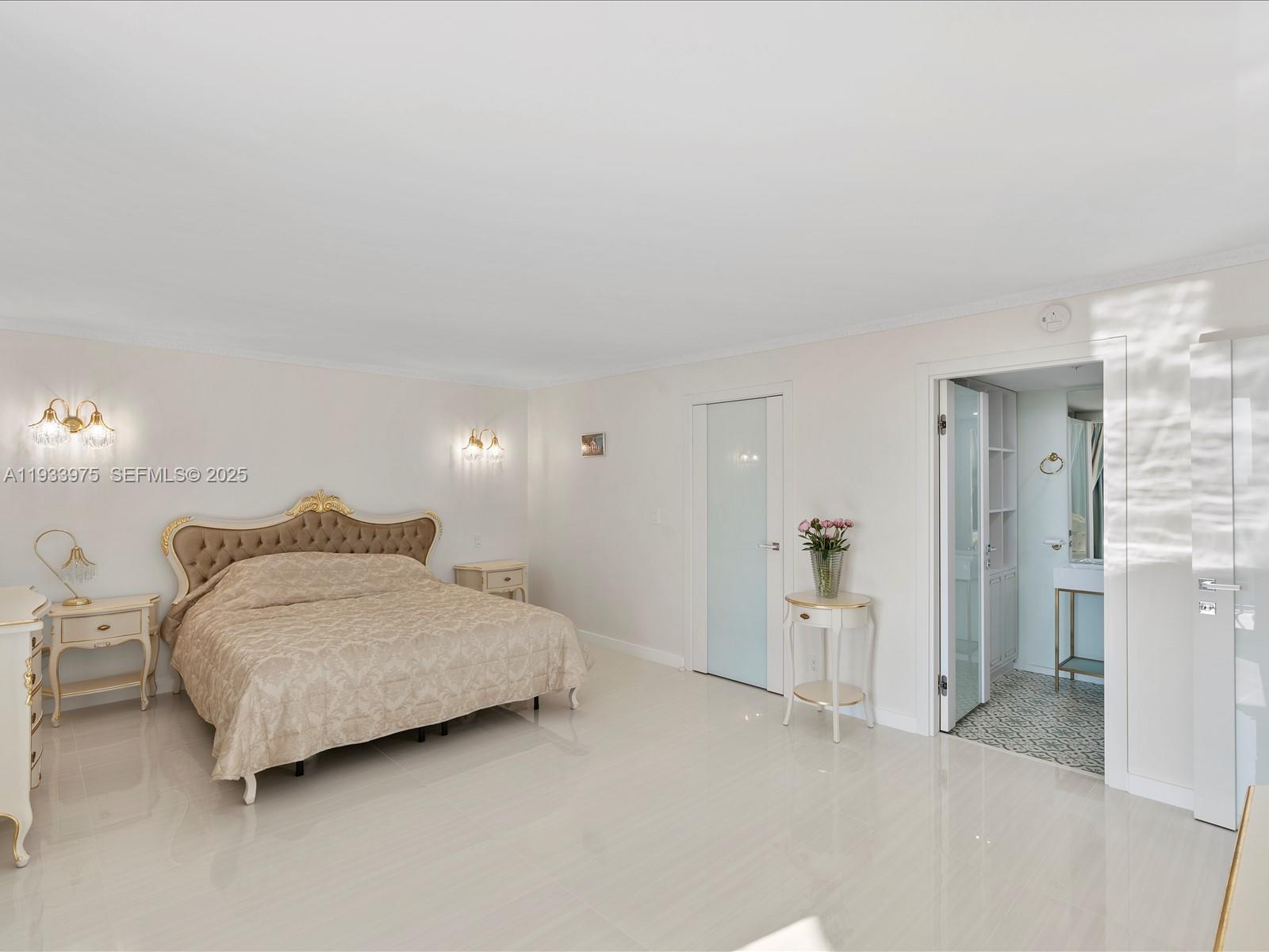 8877 Collins Avenue, Unit 704 Surfside, FL 33154 - Photo 21 of 39 a spacious bedroom with a bed and walk in closet