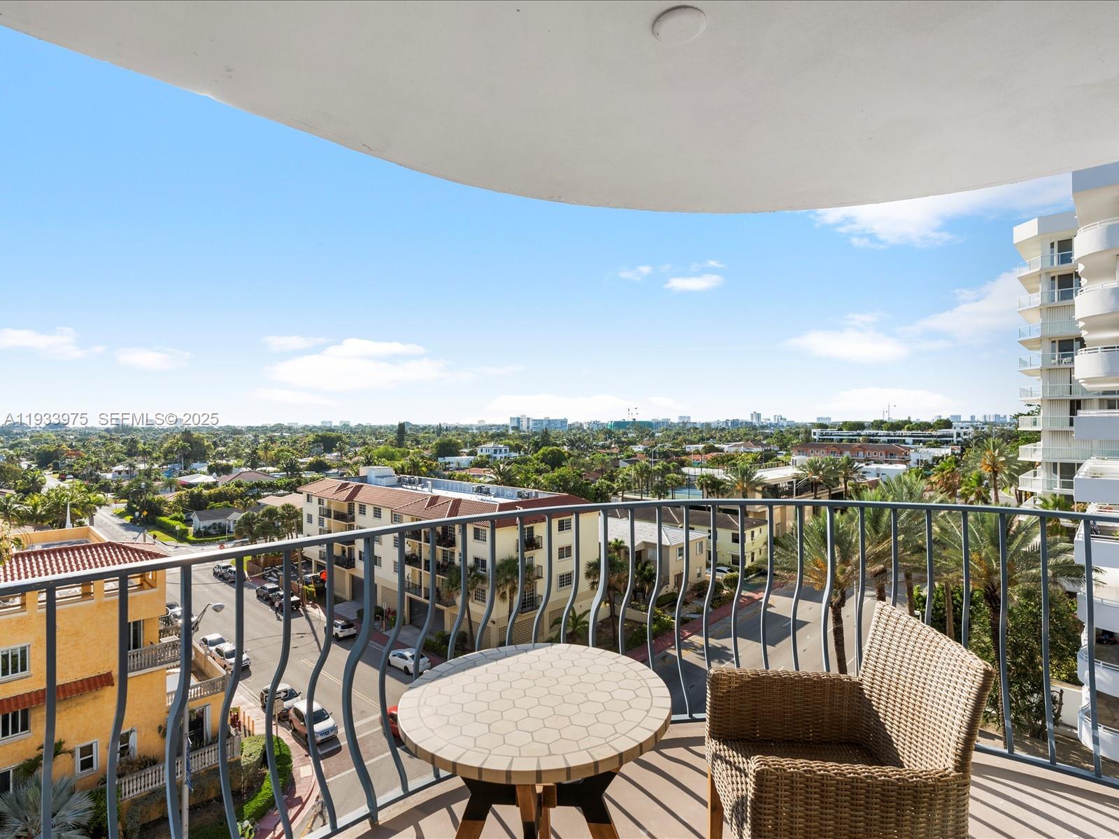 8877 Collins Avenue, Unit 704 Surfside, FL 33154 - Photo 27 of 39 a view of a balcony with wooden chairs and floor to ceiling window