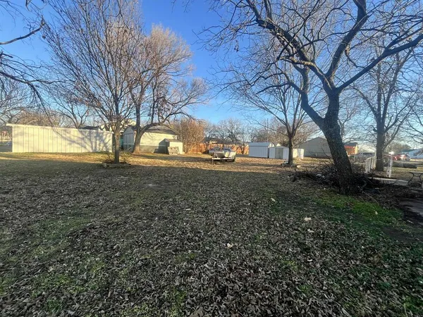 a view of yard with tree in the background