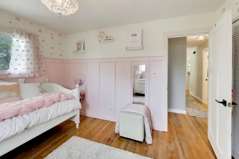 a spacious bedroom with a bed and a wooden floor