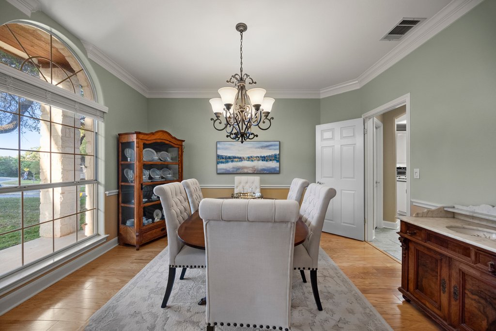 211 River Down Road Georgetown, TX 78628 - Photo 4 of 39 Crown molding and natural light create an elegant setting for entertaining.