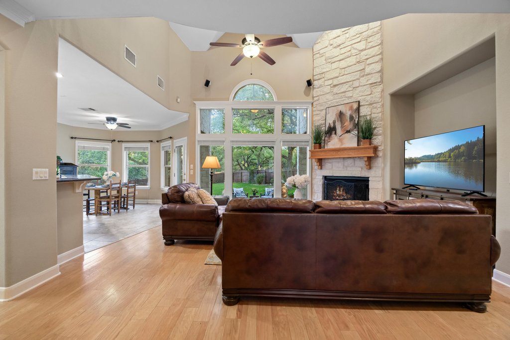 211 River Down Road Georgetown, TX 78628 - Photo 7 of 39 The dramatic living room features soaring ceilings and a stunning floor-to-ceiling stone fireplace as the focal point.