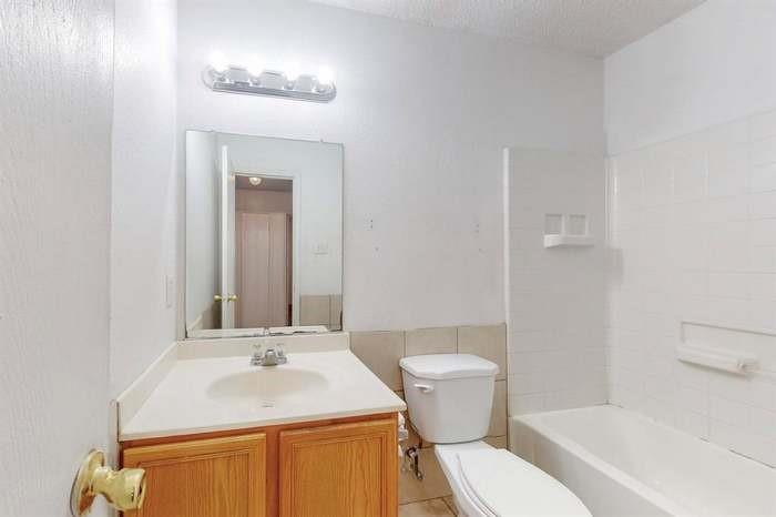 7515 Rice Lane Dallas, TX 75241 - Photo 11 of 15 Full bath with vanity, shower / bathtub combination, and a textured ceiling