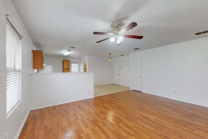 7515 Rice Lane Dallas, TX 75241 - Photo 12 of 15 Unfurnished living room featuring a ceiling fan and light wood-type flooring