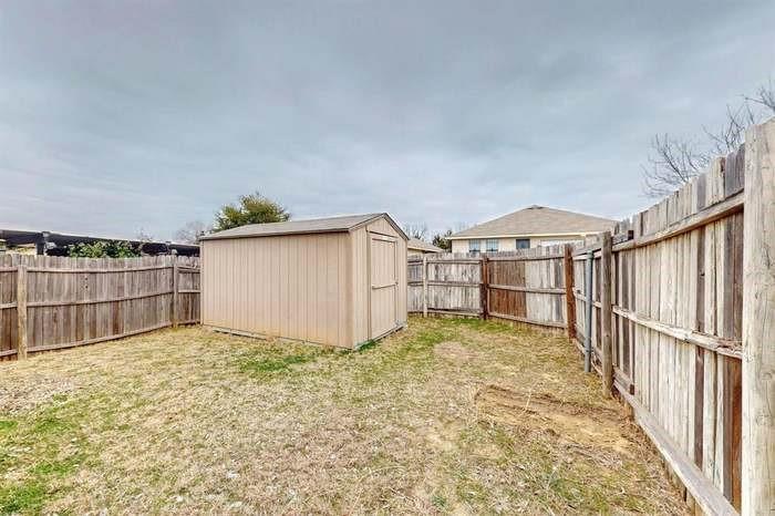 7515 Rice Lane Dallas, TX 75241 - Photo 14 of 15 Fenced backyard with a shed