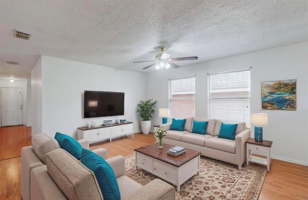 7515 Rice Lane Dallas, TX 75241 - Photo 2 of 15 Living area featuring light wood finished floors, a textured ceiling, and a ceiling fan