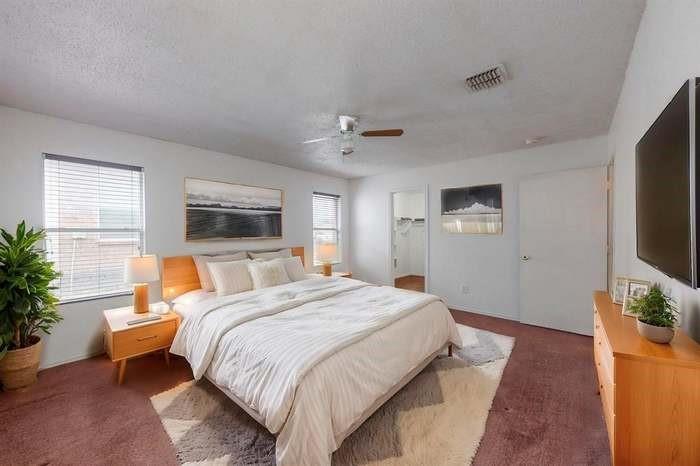 7515 Rice Lane Dallas, TX 75241 - Photo 7 of 15 Carpeted bedroom with a walk in closet, a ceiling fan, and a textured ceiling