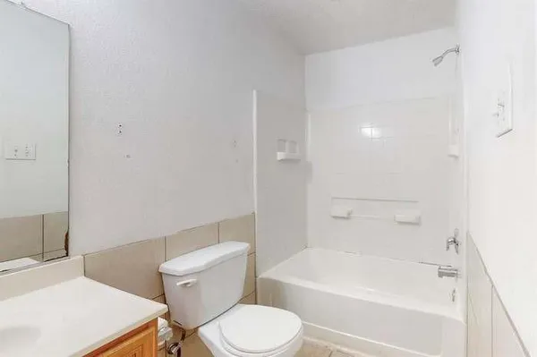 a white toilet sitting next to a bath tub