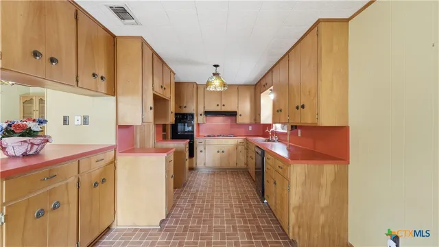 a kitchen with cabinets a sink and appliances