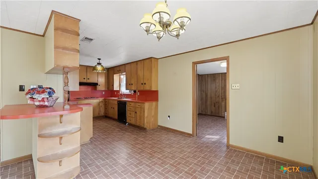 a kitchen that has a lot of cabinets a sink and a refrigerator