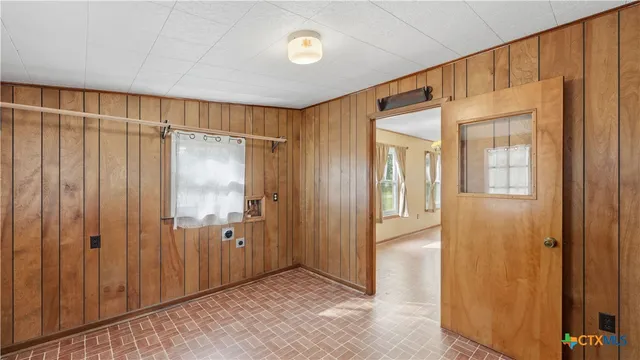 a view of a hallway with wooden shelves