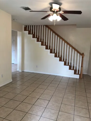 a view of staircase with white walls and fan