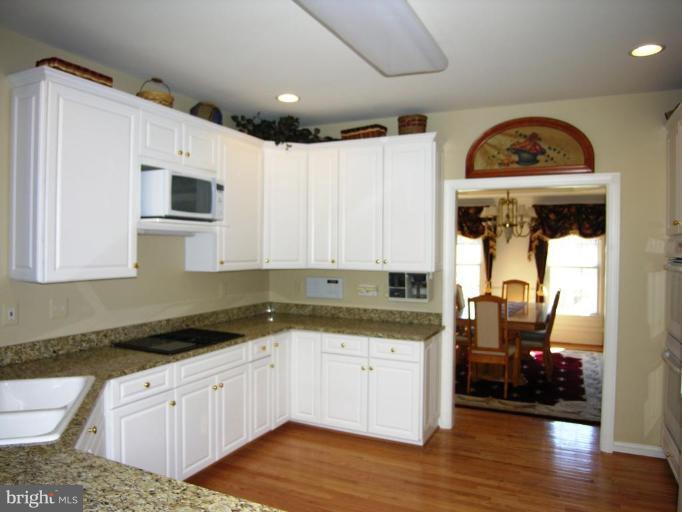 7816 Pohick Road Springfield, VA 22153 - Photo 19 of 30 a kitchen with granite countertop white cabinets and white appliances