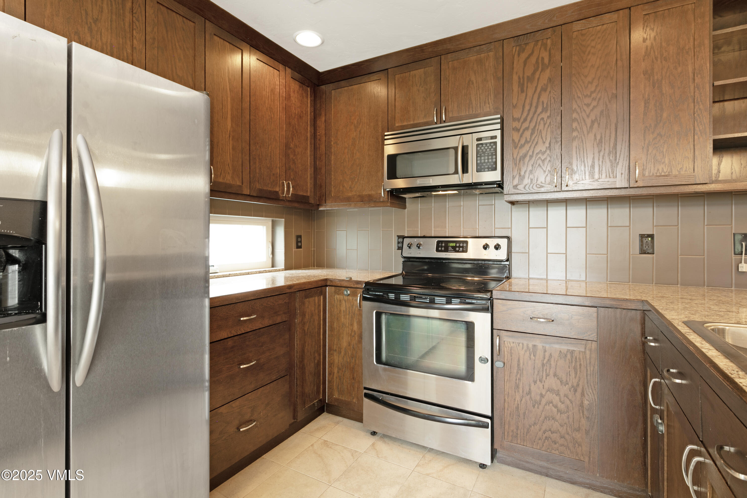 80 Freestone Road, Unit B201 Eagle, CO 81631 - Photo 9 of 24 a kitchen with stainless steel appliances granite countertop a refrigerator stove and sink