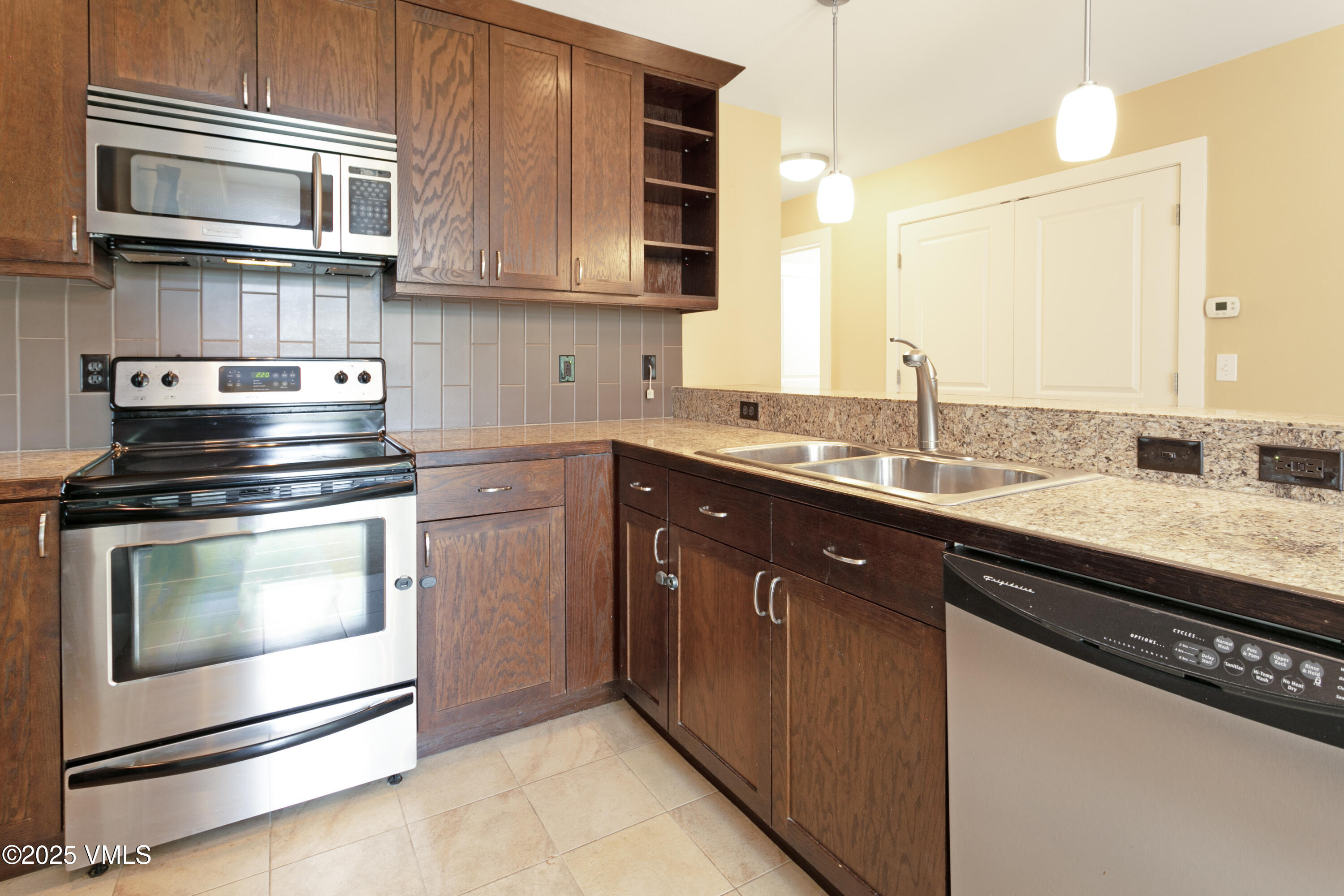 80 Freestone Road, Unit B201 Eagle, CO 81631 - Photo 10 of 24 a kitchen with stainless steel appliances granite countertop a sink stove and microwave
