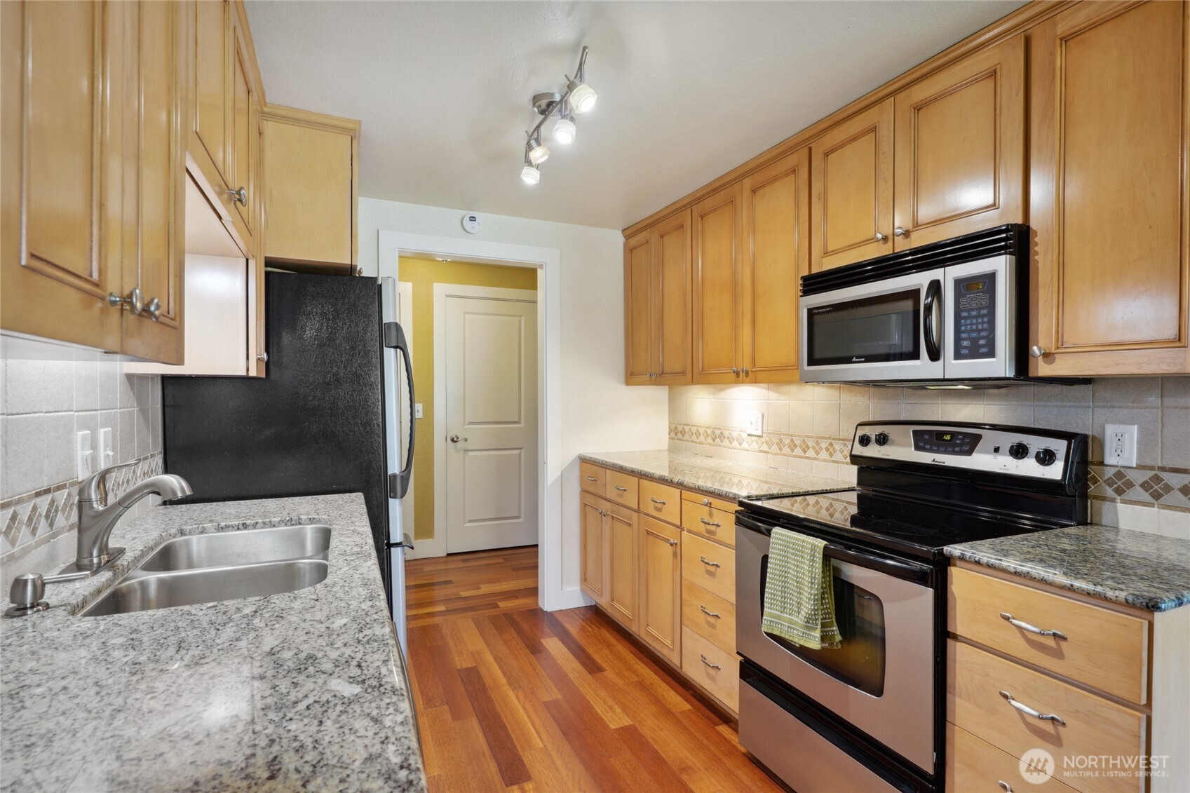 1450 Alameda Avenue, Unit 1 Fircrest, WA 98466 - Photo 7 of 19 a kitchen with granite countertop wooden cabinets stainless steel appliances and a sink