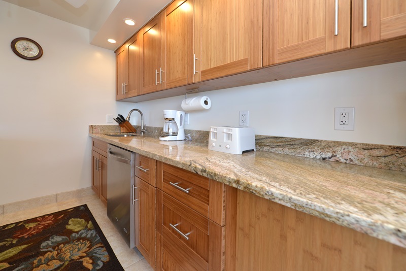 3741 Lower Honoapiilani Road, Unit 301 Lahaina, HI 96761 - Photo 6 of 18 a kitchen with granite countertop a sink a stove and cabinets