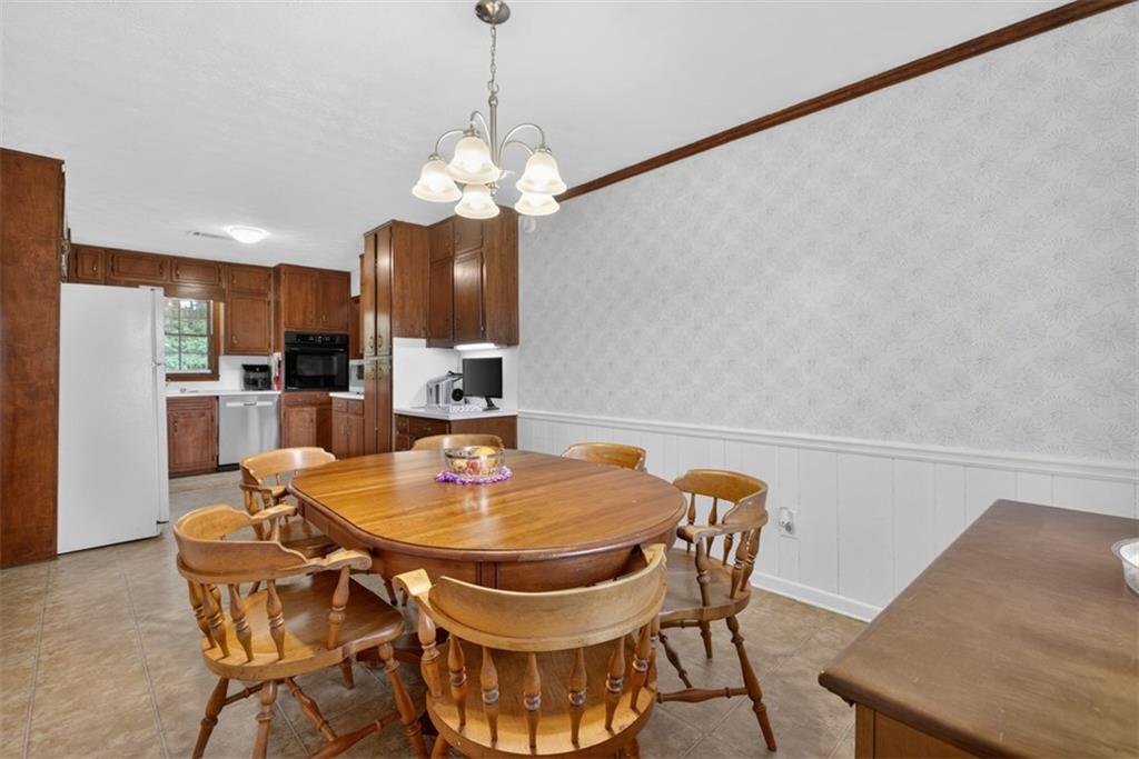 1177 Charlie Lane Southwest Lilburn, GA 30047 - Photo 19 of 49 a view of a dining room with furniture and chandelier