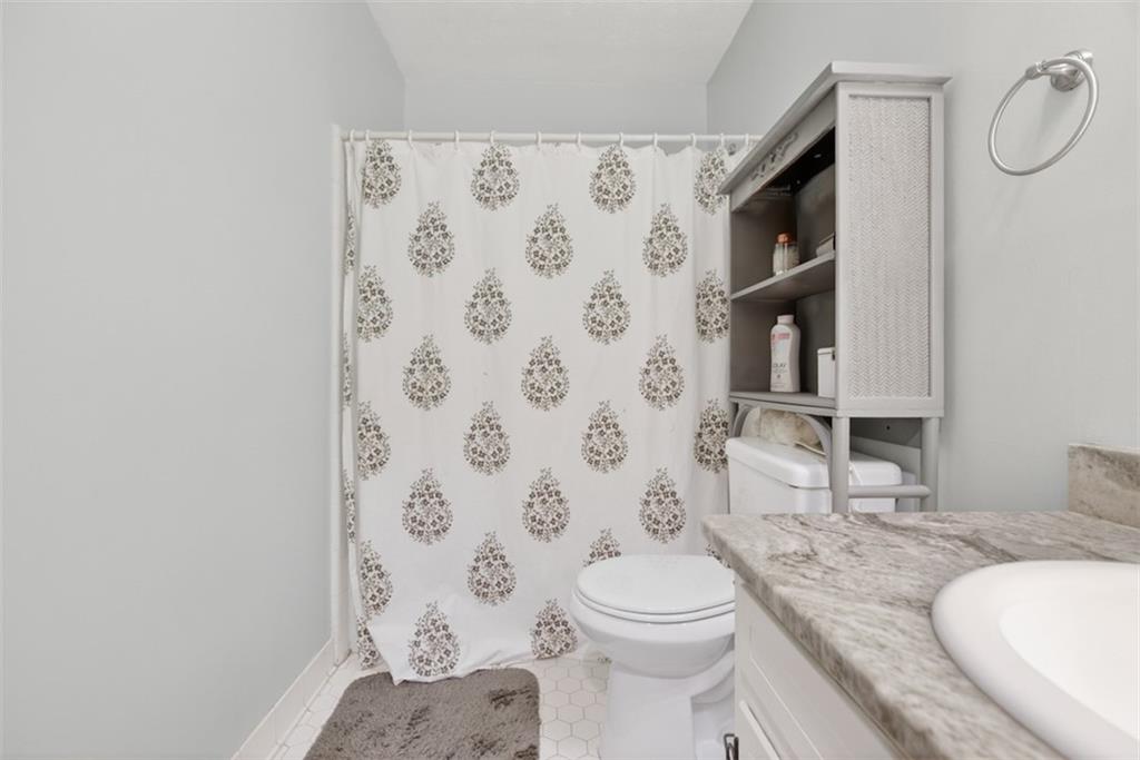 1177 Charlie Lane Southwest Lilburn, GA 30047 - Photo 26 of 49 a bathroom with a granite countertop toilet sink and shower