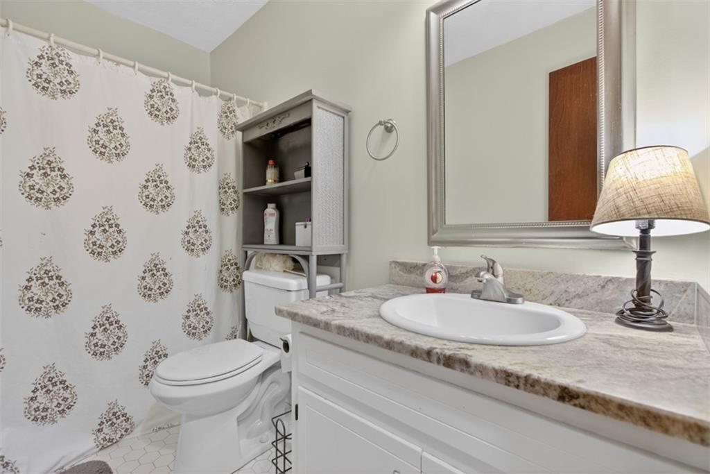 1177 Charlie Lane Southwest Lilburn, GA 30047 - Photo 27 of 49 a bathroom with a sink toilet and shower