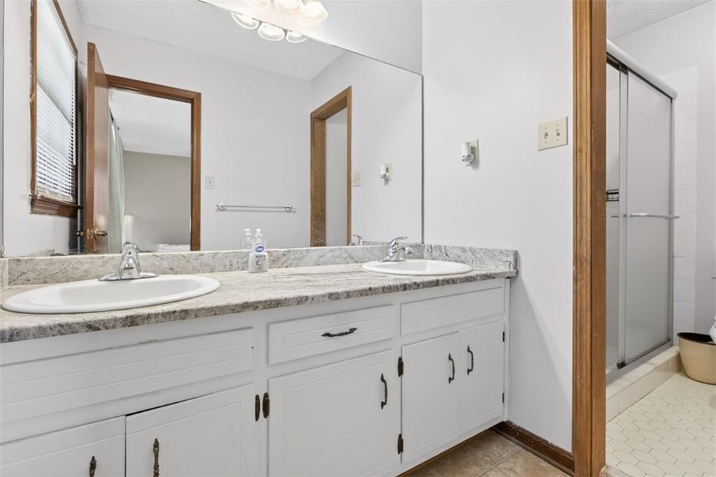 1177 Charlie Lane Southwest Lilburn, GA 30047 - Photo 40 of 49 a bathroom with a granite countertop sink and a mirror