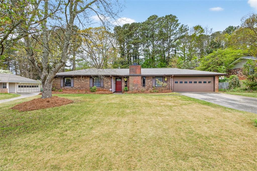 1177 Charlie Lane Southwest Lilburn, GA 30047 - Photo 4 of 49 a view of a house with a large tree and a yard