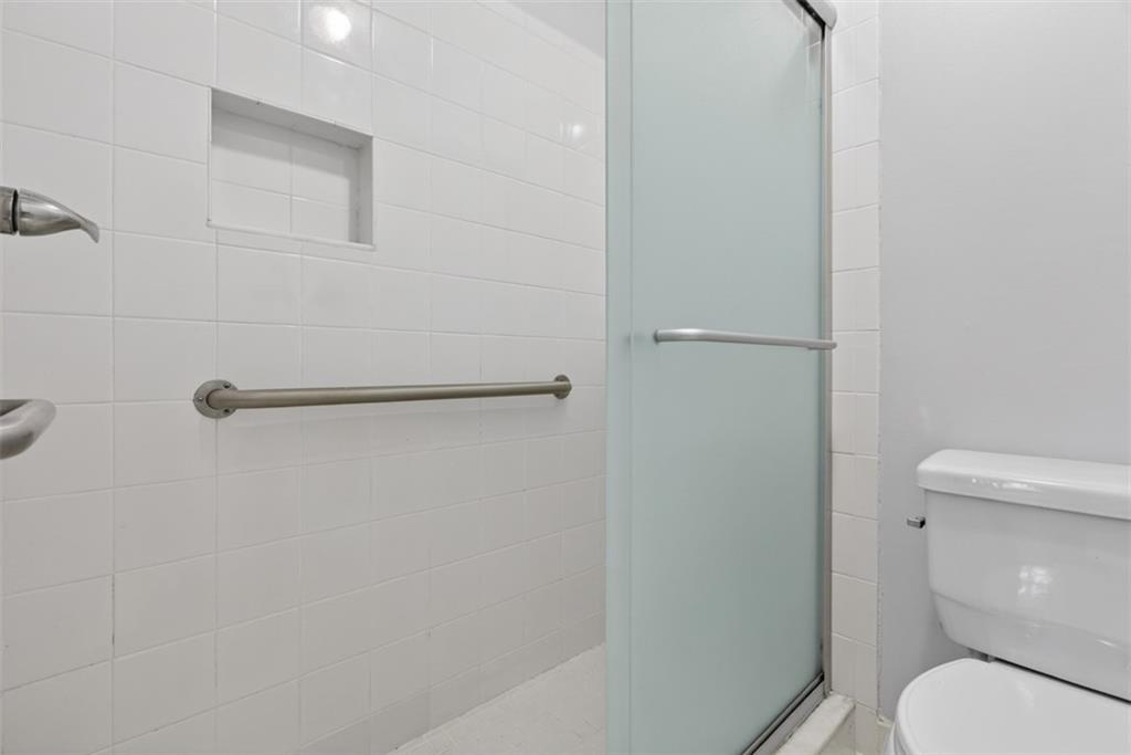 1177 Charlie Lane Southwest Lilburn, GA 30047 - Photo 41 of 49 a white toilet sitting next to a shower