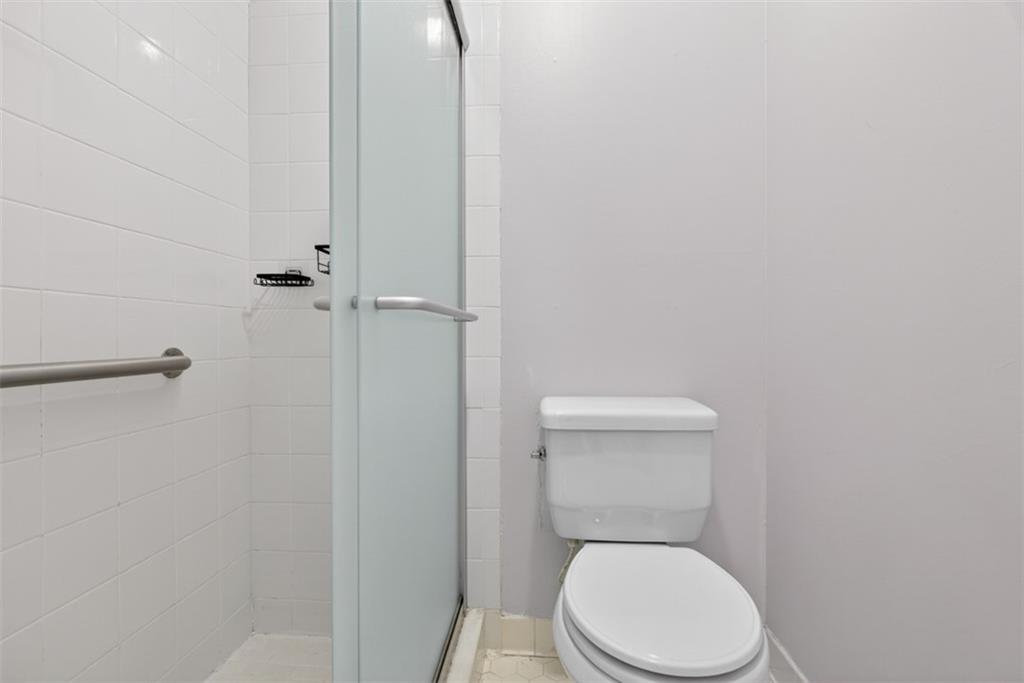1177 Charlie Lane Southwest Lilburn, GA 30047 - Photo 42 of 49 a white toilet sitting next to a shower