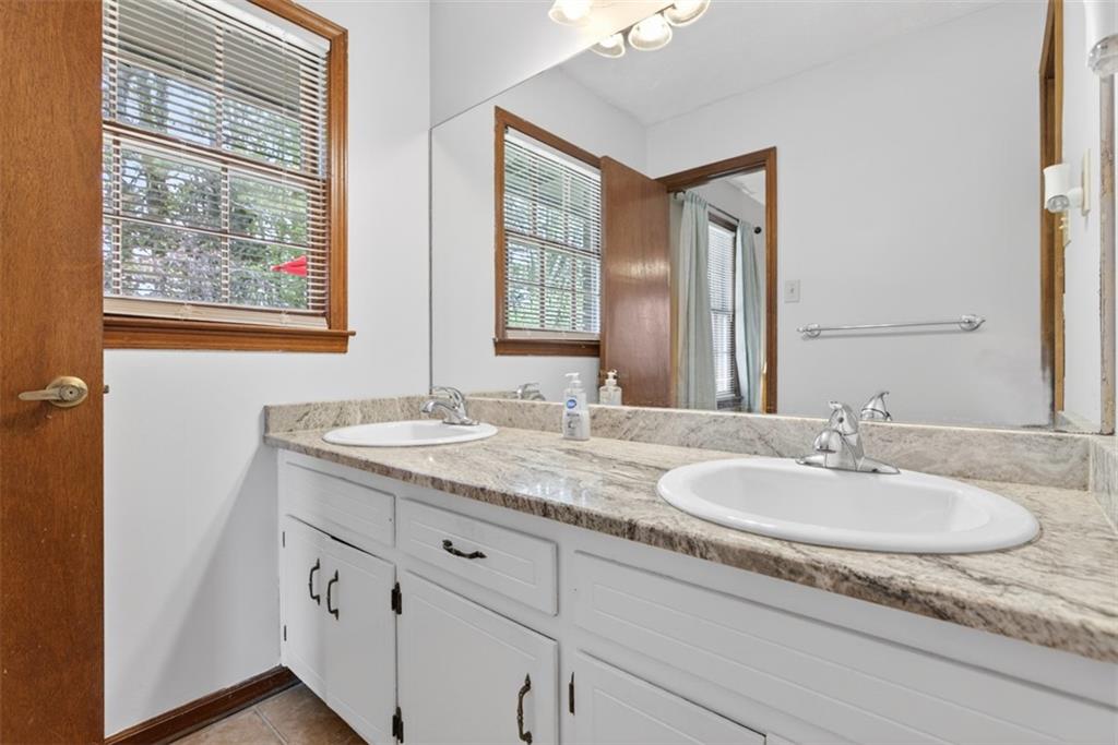 1177 Charlie Lane Southwest Lilburn, GA 30047 - Photo 43 of 49 a bathroom with double sink and a mirror